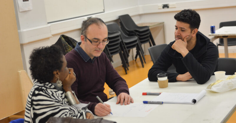 three people sitting around a table